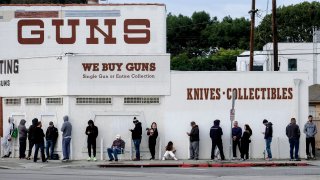 People wait in line to enter a gun store