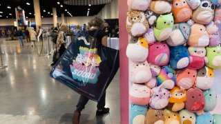 A shareholder leaves the Squishmallows booth with a large bag of purchases in the exhibition hall of the Berkshire Hathaway annual meeting on Saturday, May 6, 2023, in Omaha, Neb.