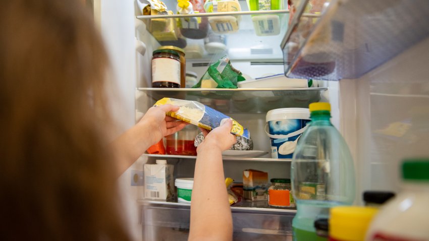 FILE: Woman taking food out of the refrigerator.