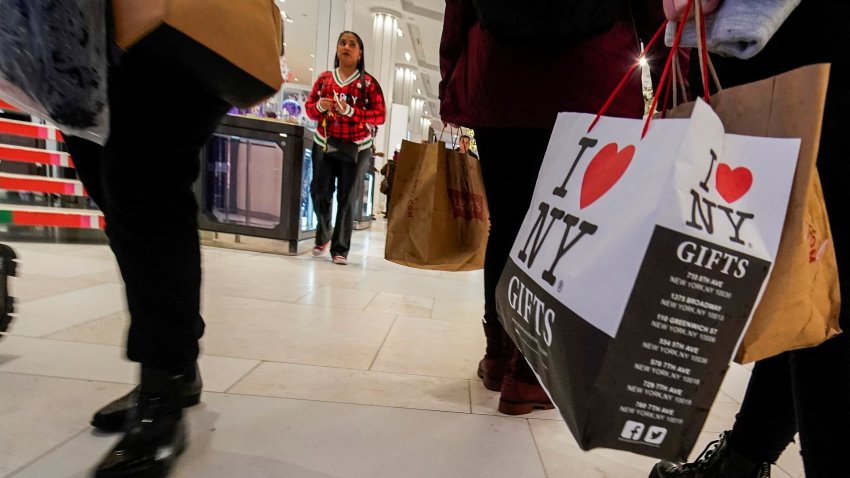 People carry shopping bags as they visit a department store during the holiday season in New York City.