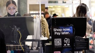 FILE -- A sign displays credit card and buy now, pay later information as customers visit Macy’s Herald Square store in New York City, Dec. 17, 2023.