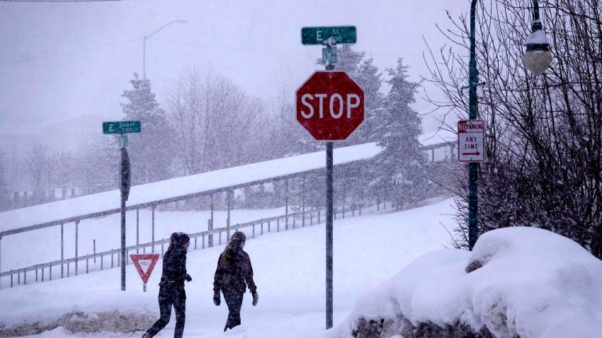 People walk in snow in Anchorage, Alaska, the United States, on March 15, 2021