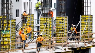 Construction workers erect a building in downtown Miami, Florida, on June 14, 2023.