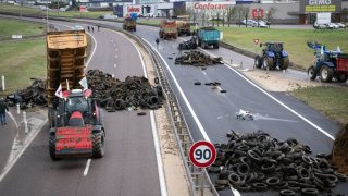 A farmer pulls waste to block the RN 19 near in Vesoul, eastern France, on January 25, 2024. 