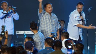 Prabowo Subianto, Indonesia’s presidential candidate and defense minister, center, waves to supporters in Jakarta, Indonesia, on Wednesday, Feb. 14, 2024. Prabowo declared victory in Wednesday’s presidential vote, citing independent pollsters, putting him on course to lead Southeast Asia’s largest economy after two failed attempts. 