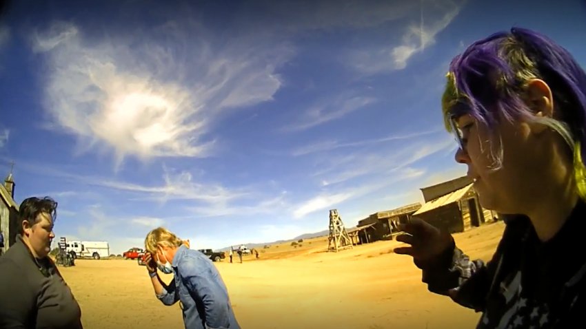 In this screen grab from lapel camera video provided by the Santa Fe County Sheriff’s Office, movie set armorer Hannah Gutierrez-Reed, right, speaks with a sheriff’s deputy as other colleagues, at center and left, react on the set of the western move “Rust,” shortly after the fatal shooting of cinematographer Halyna Hutchins by Alec Baldwin during a rehearsal, Oct. 21, 2021, in New Mexico. The scheduled trial next week of the movie weapons supervisor in the fatal shooting of a cinematographer by Alec Baldwin may hinge on an enduring mystery: How did live ammunition find its way onto the set of a film set where it was expressly prohibited?