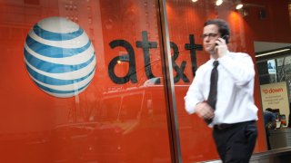 A pedestrian passes an AT&T store in New York, U.S.