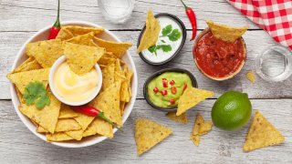 Mexican nacho chips with various sauces - guacamole, salsa, cheese and sour cream.