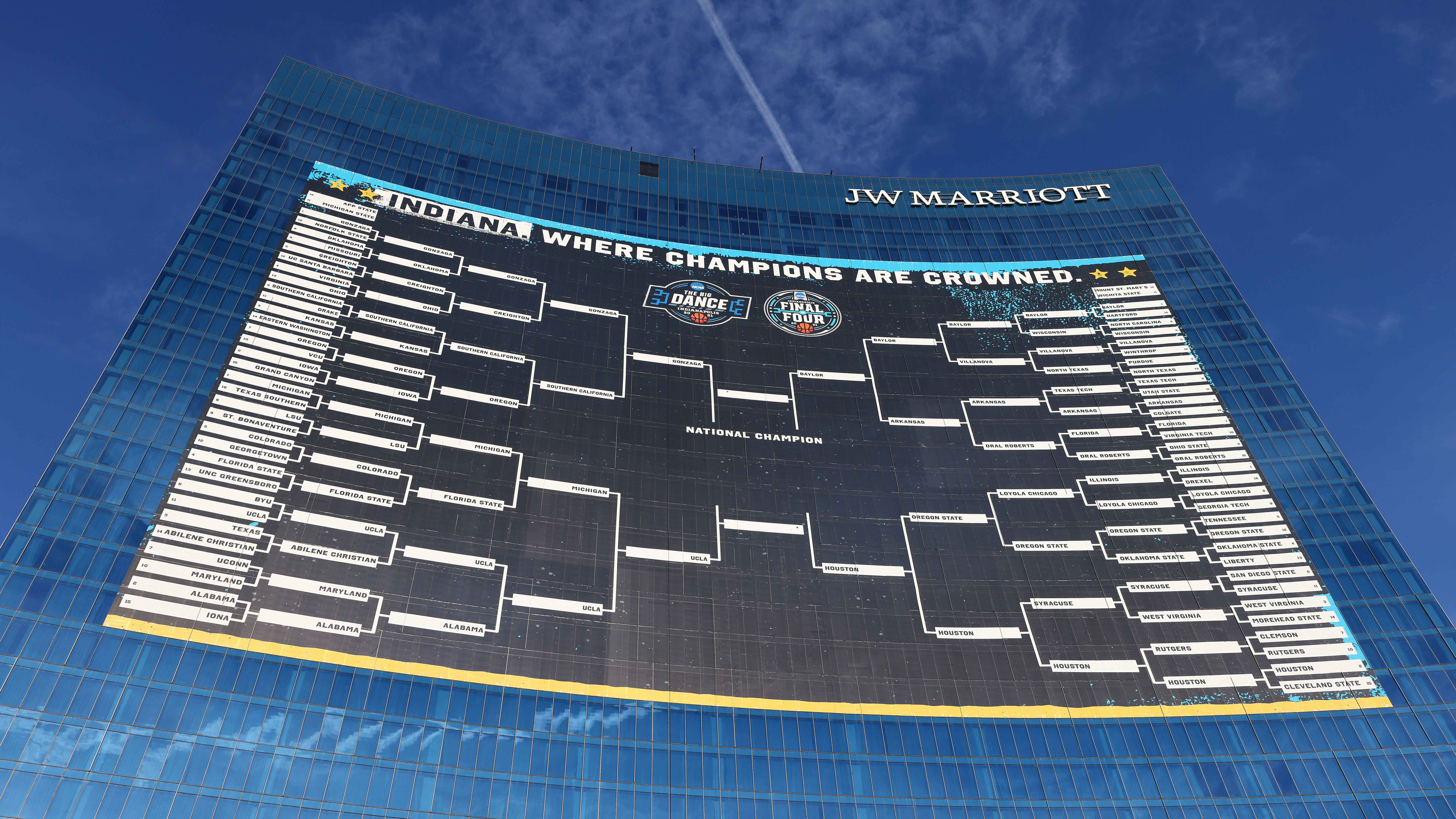 Exterior picture of the JW Marriott Hotel with the entire bracket of the NCAA Men’s Basketball Tournament hanging on its building