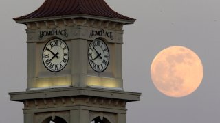 The moon rises behind the Home Place clock tower in Prattville, Ala.