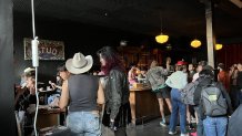 Guests line up at the bar to get drinks at the re-opening celebration for the Stud, San Francisco's oldest continuously operated gay bar. Stud Collective members say the new location is decorated with details from the old bar, including a sign made by Stud bartenders in the 1970s. April 20, 2024. NBC Bay Area Photo/ Alyssa Goard.
