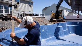 Ordini’s Best Fiberglass Pools contractors work to install a pool, which the company says have dramatically increased in sales due to COVID-19 fears, in Gilbertsville, Pennsylvania, April 26, 2021.