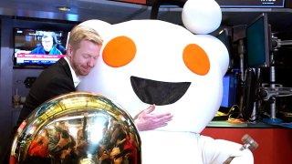 Reddit CEO Steve Huffman hugs mascot Snoo as Reddit begins trading on the New York Stock Exchange (NYSE) in New York on March 21, 2024.