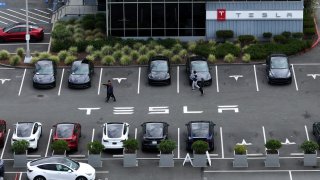 In an aerial view, brand new Tesla cars sit parked in a lot at the Tesla Fremont Factory in Fremont, California, April 24, 2024.