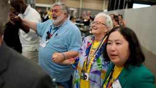 David Meredith, left, and Jan Lawrence react after an approval vote at the United Methodist Church General Conference Wednesday, May 1, 2024, in Charlotte, N.C.  United Methodist delegates repealed their church’s longstanding ban on LGBTQ clergy with no debate on Wednesday, removing a rule forbidding “self-avowed practicing homosexuals” from being ordained or appointed as ministers.