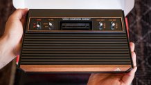 A new Atari 2600+ game console, held in two hands.