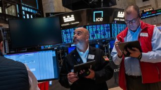 Traders walk the floor during morning trading at the New York Stock Exchange on May 14, 2024.