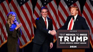 Kathryn Burgum aplauds as her husband Republican Governor of North Dakota Doug Burgum shakes hands with former US President and 2024 presidential hopeful Donald Trump during a Caucus Night watch party in Las Vegas, Nevada, on February 8, 2024. 