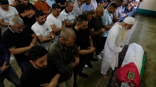 Palestinian mourners pray at the body of Mohammad Hoshiya, 12, during his funeral in the West Bank village of Qatana, southwest of Ramallah Saturday, June 22, 2024. The Palestinian Health Ministry said Hoshiya died from his wounds after being shot by Israeli forces in Ramallah last week.