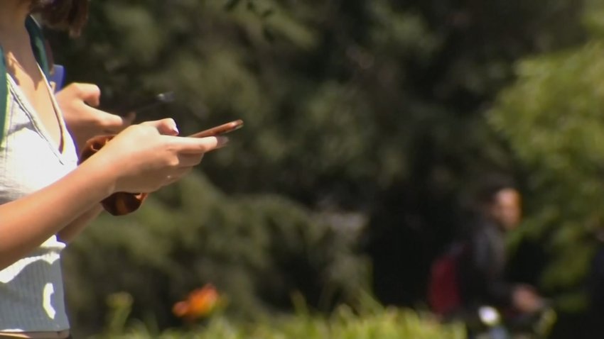 Teenager holding a cellphone at a US school.