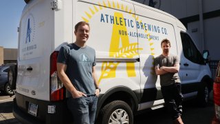 Company founder Bill Shufelt (left) and head brewer John Walker pause at the Athletic Brewing’s nonalcoholic brewery and production plant on March 20, 2019 in Stratford, Connecticut.