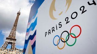 The Paris 2024 logo, representing the Olympic Games is displayed near the Eiffel Tower three months prior to the start of the Paris 2024 Olympic and Paralympic games on April 21, 2024 in Paris, France.