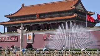 People walk around the Tiananmen Gate in Beijing on May 15, 2024.