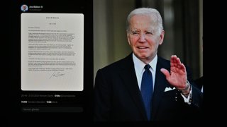 The letter in which U.S. President Joe Biden announced his withdrawal from candidacy is being displayed on a mobile phone screen in front of a computer screen displaying a photo of President Biden on July 21.