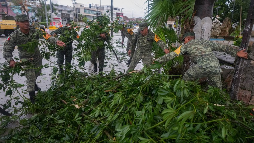 Soldiers collect branches felled by Hurricane Beryl, in Tulum, Mexico, Friday, July 5, 2024.