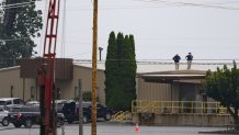 BUTLER, PENNSYLVANIA - JULY 14: Two FBI investigators scan the roof of AGR International Inc, the building adjacent to the Butler Fairgrounds, from which alleged shooter Matthew Thomas Crooks fired at former President Donald J. Trump, in the aftermath of the attempted assassination at a campaign rally on July 14, 2024 in Butler, Pennsylvania. Trump was escorted away by the Secret Service with an injury to his ear. One attendee at the rally on July 13 was killed and two others severely injured. (Photo by Jeff Swensen/Getty Images)