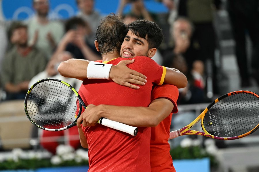 Spain's Rafael Nadal (L) and Spain's Carlos Alcaraz (R) embrace after beating Argentina's Maximo Gonzalez and Argentina's Andres Molteni