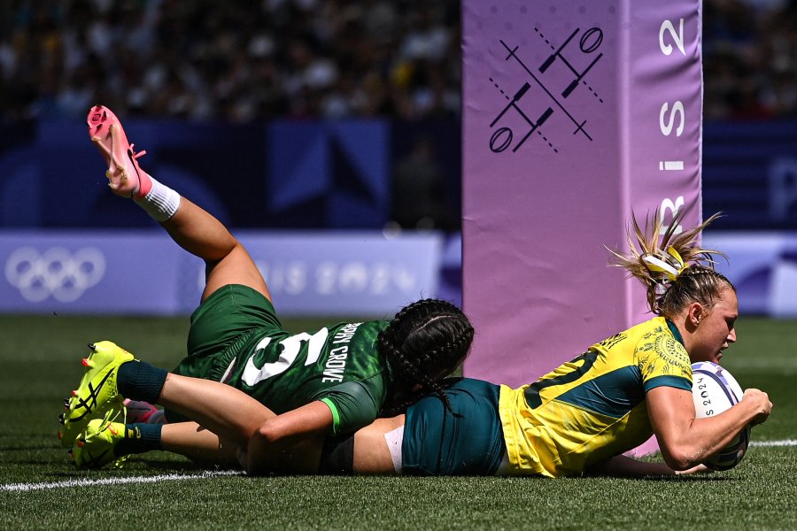 Australia's Maddison Levi (R) scores a try as tackled by Ireland's Amee Leigh Murphy Crowe (L) during the women's pool B rugby sevens match