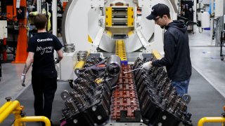 Workers assemble components on a diesel engine at the Cummins Seymour Engine Plant in Seymour, Indiana, on Monday, April 18, 2022.