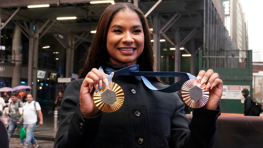 Two-time U.S. Olympic gymnast medalist Jordan Chiles shows her medals after ringing the closing bell at the Nasdaq MarketSite, in New York's Times Square, Thursday, Aug. 8, 2024.