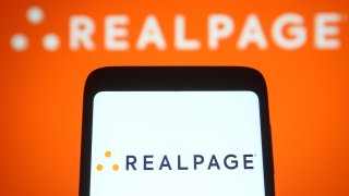 In this photo illustration a RealPage logo of an US software company is seen on a smartphone and a pc screen.