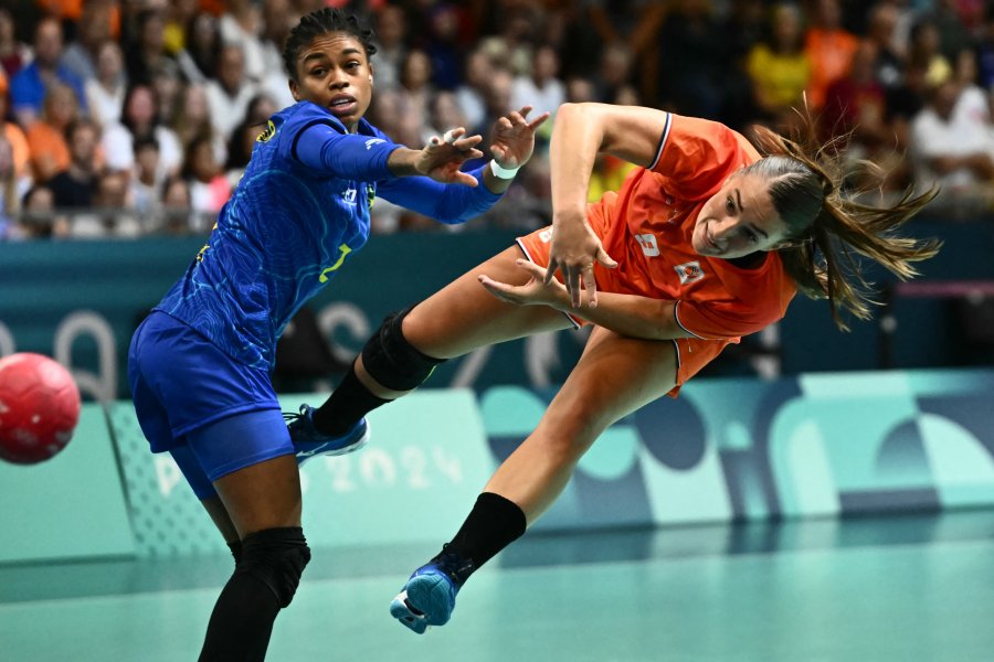 Netherlands' centre back Larissa Nusser attempts to score next to Brazil's centre back Bruna de Paula during the Women's Preliminary Round Group B handball match