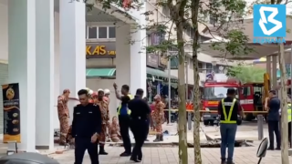 Rescue personnel respond after receiving reports that a woman has fallen into a sinkhole after a section of the sidewalk caved in Kuala Lumpur.