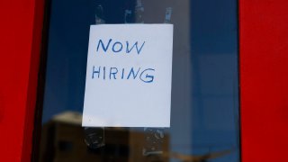 A “Now Hiring” sign is displayed on a storefront in Adams Morgan Neighborhood on October 07, 2022 in Washington, DC.