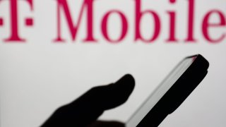 The T-Mobile logo is displayed on a laptop screen and a smartphone, seen in this illustration photo taken in Krakow, Poland, Feb. 22, 2024.