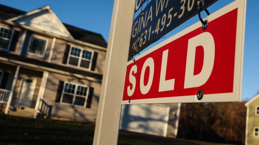 A home with a “Sold” sign from a real estate company in North Patchogue, New York.