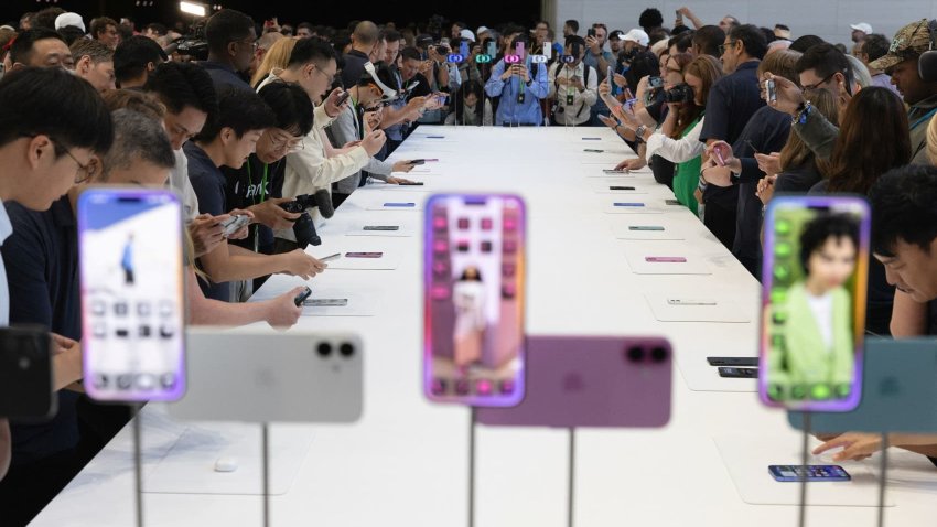 Attendees try the new iPhone 16 as Apple holds an event at the Steve Jobs Theater on its campus in Cupertino, California, U.S. September 9, 2024. 