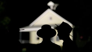 Amish men are seen in front of the schoolhouse