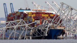 The cargo ship Dali is stuck under part of the structure of the Francis Scott Key Bridge after the ship hit the bridge, Tuesday, March 26, 2024, as seen from Pasadena, Md.