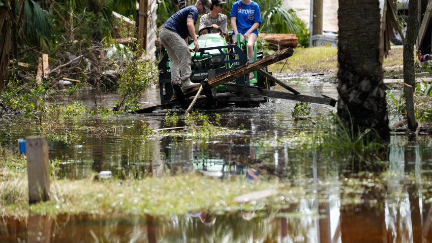 People move debris from a damaged home in the aftermath of Hurricane Helene, in Horseshoe Beach, Fla., Saturday, Sept. 28, 2024.