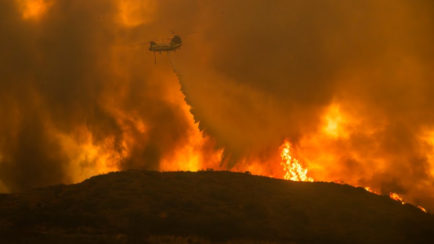 A Cal Fire helicopter makes water drop on the Airport Fire