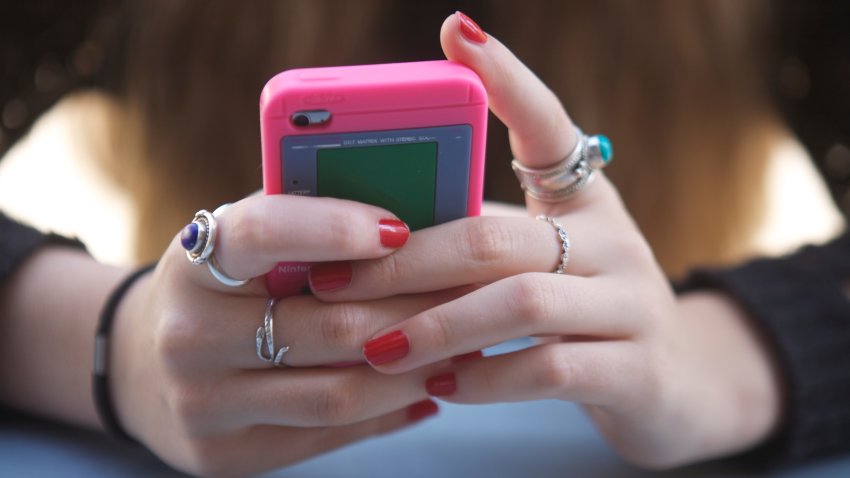 Hands holding pink phone