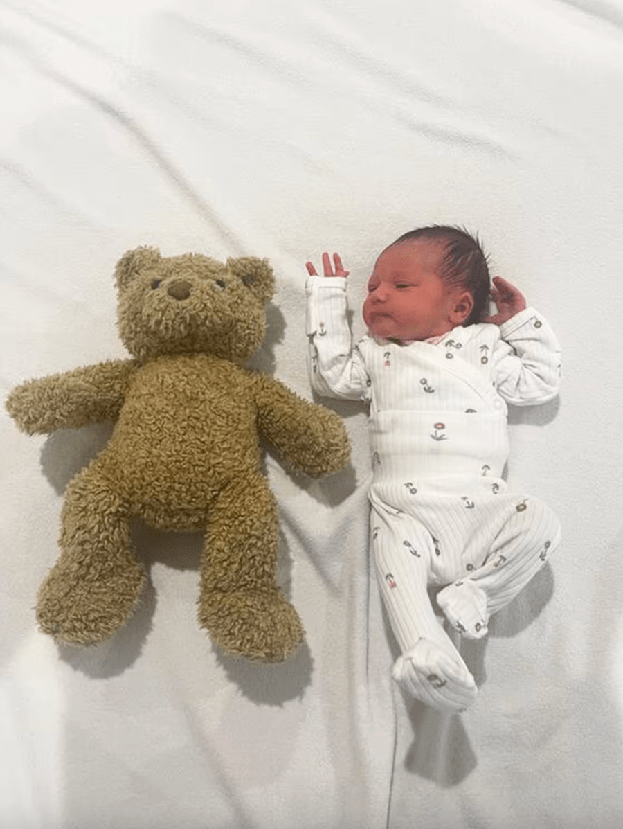 Baby next to a teddy bear for scale