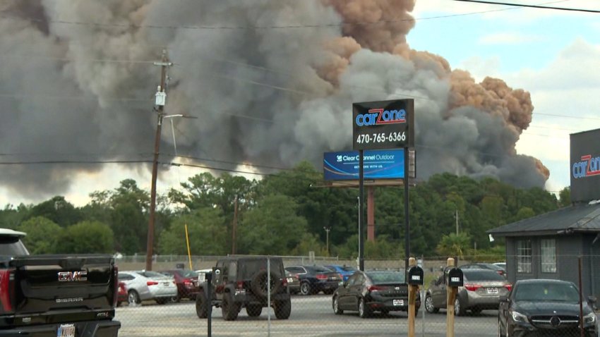 Plumes of smoke in background caused by chemical fire