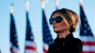 Outgoing First Lady Melania Trump listens as her husband Outgoing US President Donald Trump addresses guests at Joint Base Andrews in Maryland on January 20, 2021. 