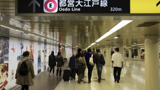 A walkway with sign of subway line in a Tokyo subway station.